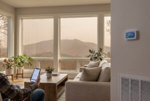 Wildfire smoke haze outside window and thermostat, improving indoor air quality in Raleigh NC home.